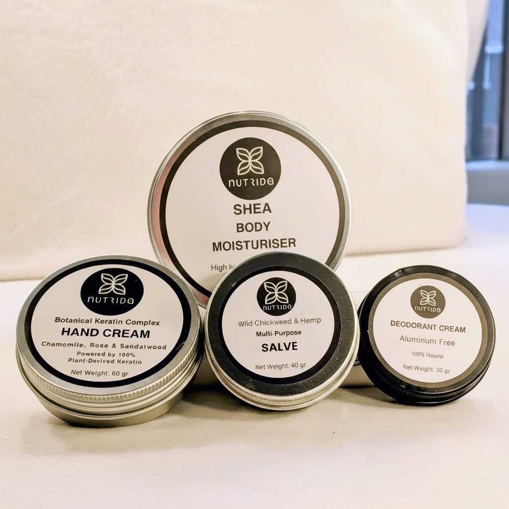 Collection of Nutrida skin care products including hand cream, body moisturizer, salve, and deodorant on a light background.