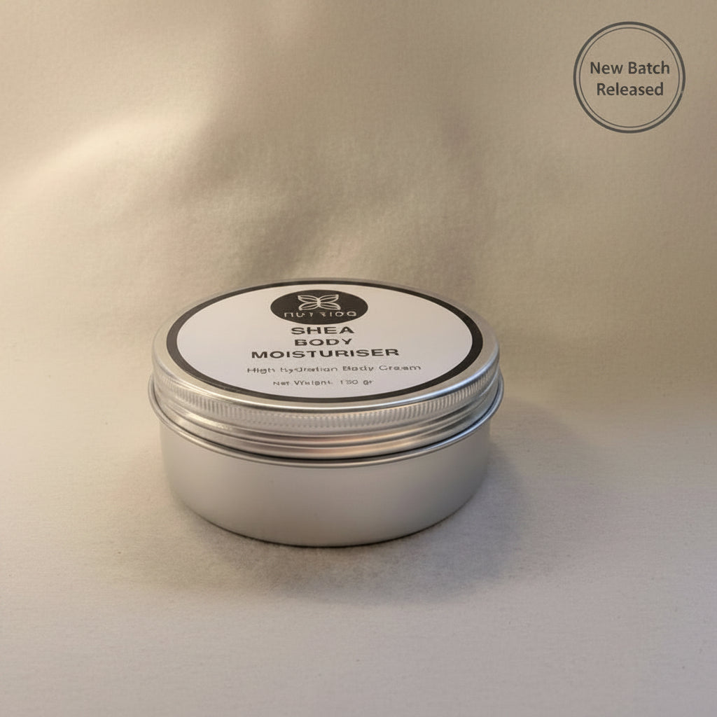 Shea body moisturizer in a metal tin with a white label on a beige background