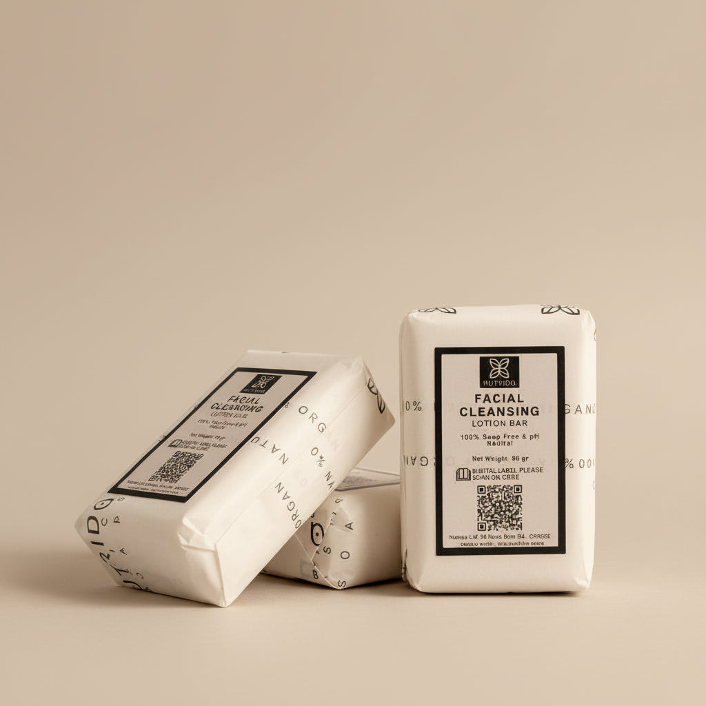 Four wrapped facial cleansing lotion bars arranged on a light fabric surface, with one bar standing upright and three lying down. The packaging is cream-colored with black text and small floral line drawings.