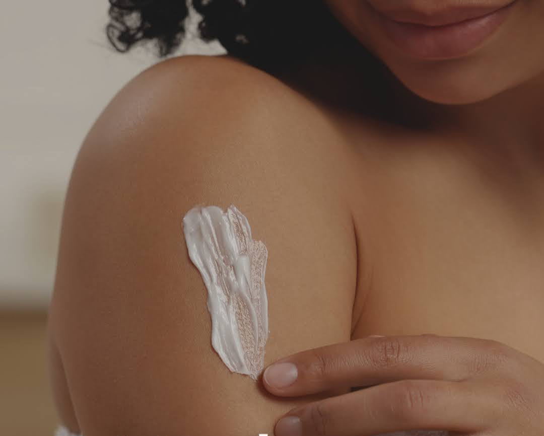 Person applying cream to their shoulder with 'Hydrate' text overlay